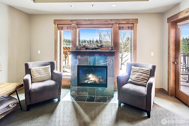 sitting room featuring plenty of natural light, carpet, a fireplace, and baseboards