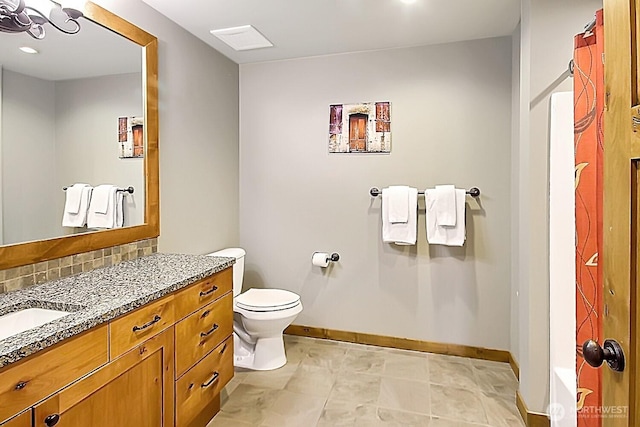 bathroom featuring baseboards, toilet, vanity, and decorative backsplash