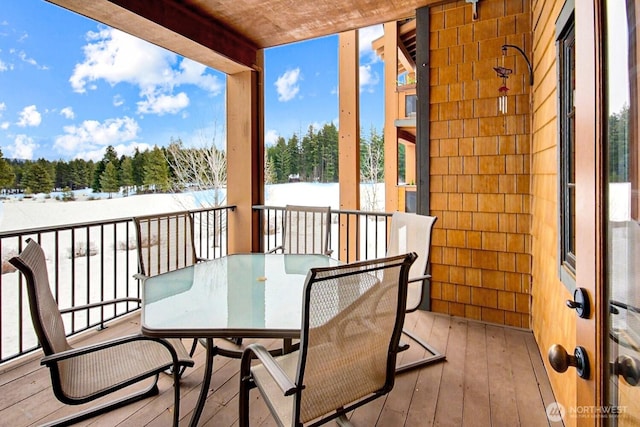 snow covered back of property with outdoor dining area