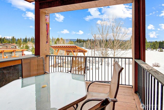 snow covered back of property with outdoor dining space