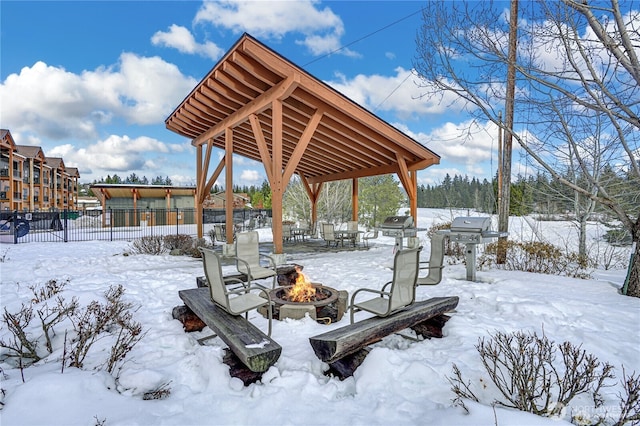 surrounding community with fence, a fire pit, and a gazebo