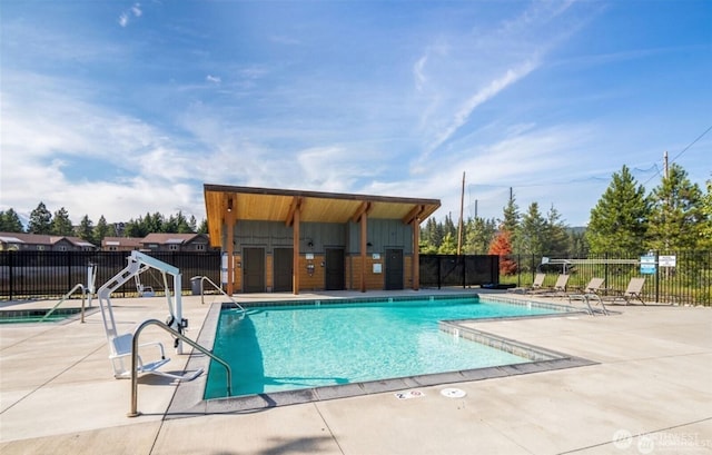 community pool featuring fence and a patio