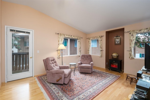 living area featuring vaulted ceiling and wood finished floors