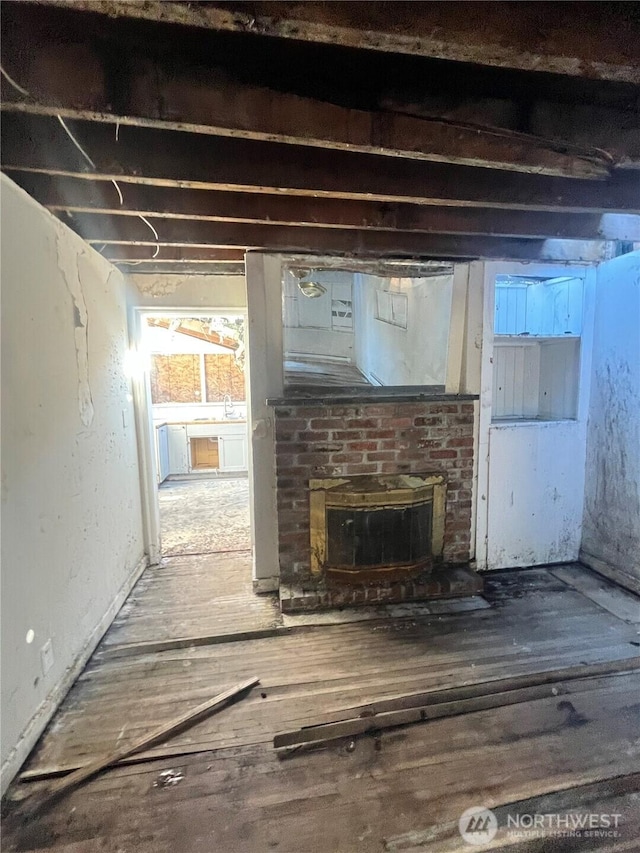 interior space with a wood stove, a sink, and wood finished floors