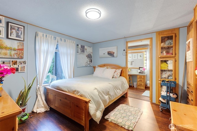 bedroom featuring a textured ceiling and wood finished floors