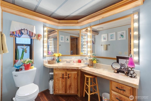 bathroom with ornamental molding, vanity, and toilet