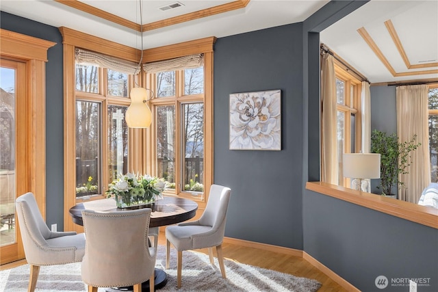 dining room featuring baseboards, visible vents, and wood finished floors