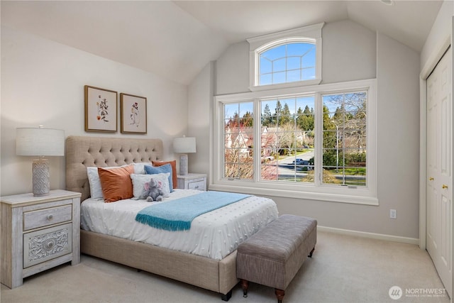 carpeted bedroom with baseboards and vaulted ceiling