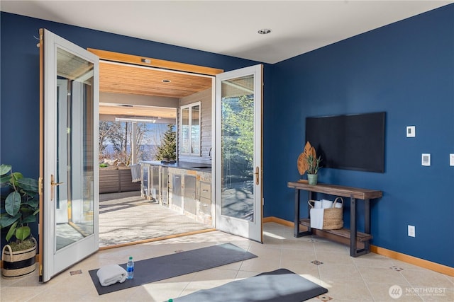 doorway featuring tile patterned flooring and baseboards