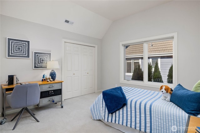 bedroom featuring light colored carpet, a closet, visible vents, and lofted ceiling