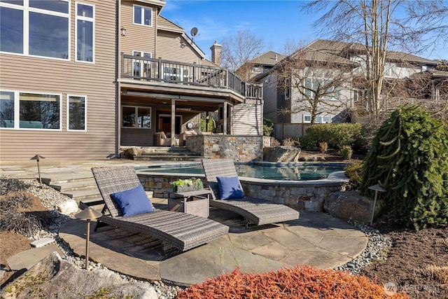 view of patio / terrace with stairs, a deck, and an outdoor pool