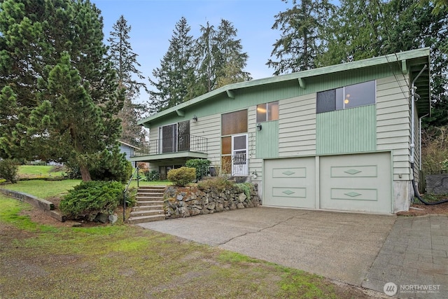 raised ranch with driveway, stairway, and an attached garage