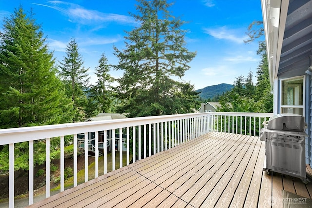 wooden deck featuring a mountain view and area for grilling