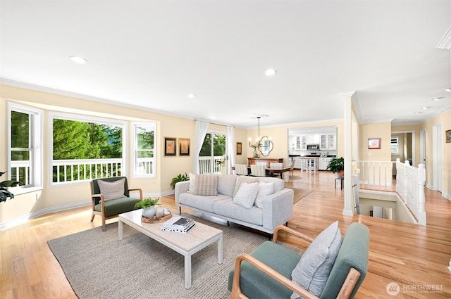 living room with a chandelier, recessed lighting, light wood-style flooring, and crown molding