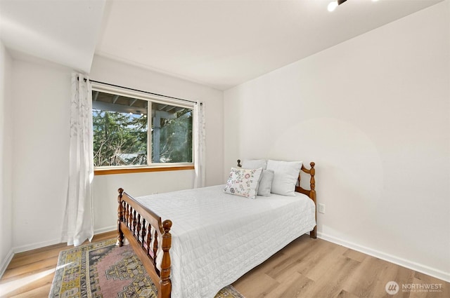 bedroom with wood finished floors and baseboards