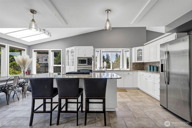 kitchen with light stone counters, lofted ceiling, backsplash, appliances with stainless steel finishes, and glass insert cabinets