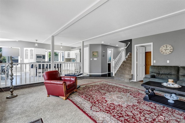 living area featuring stairway, carpet flooring, and baseboards