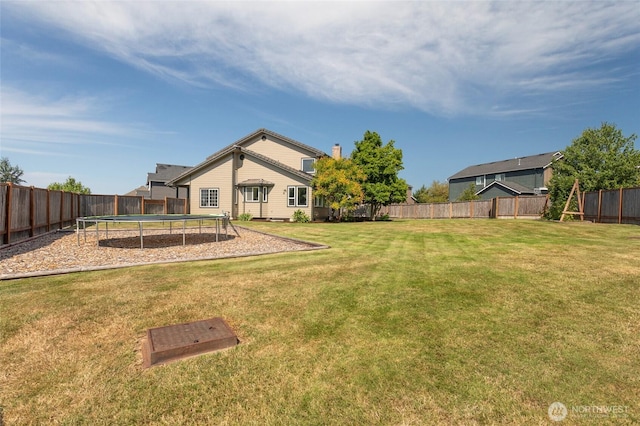 view of yard with a trampoline and a fenced backyard