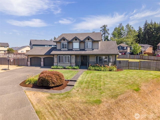 view of front of property featuring aphalt driveway, an attached garage, fence, a tiled roof, and a front yard