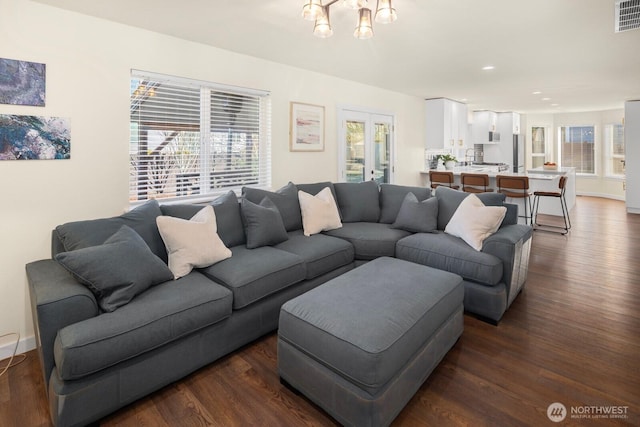 living room featuring recessed lighting, visible vents, dark wood-type flooring, a chandelier, and baseboards