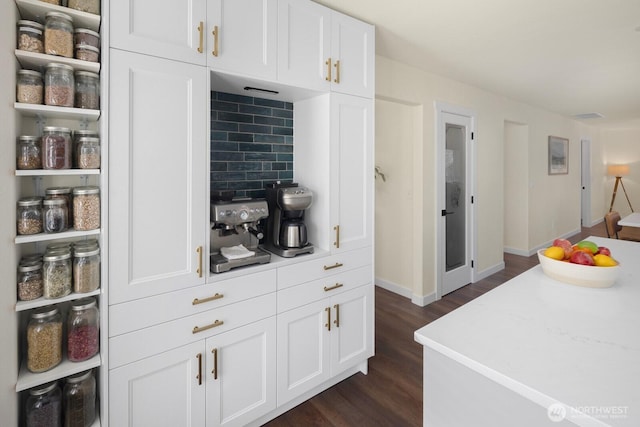 kitchen featuring tasteful backsplash, white cabinetry, light countertops, and dark wood finished floors