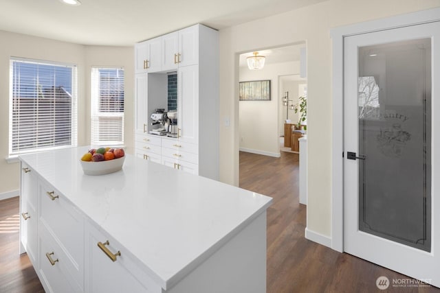 kitchen featuring baseboards, white cabinetry, dark wood finished floors, and light countertops