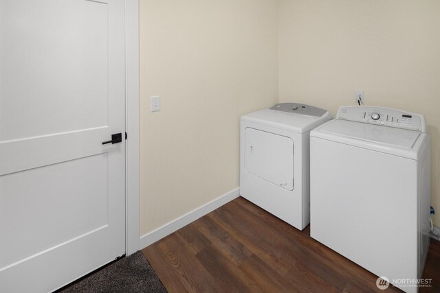 laundry area featuring dark wood-style floors, laundry area, washing machine and clothes dryer, and baseboards