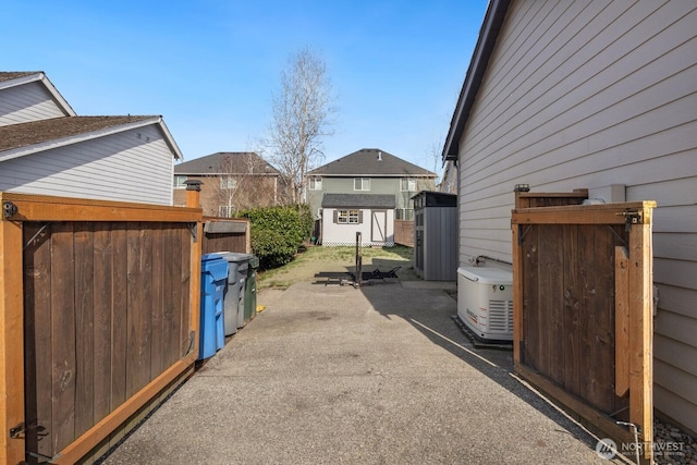 view of yard featuring a patio, a storage unit, an outdoor structure, and fence