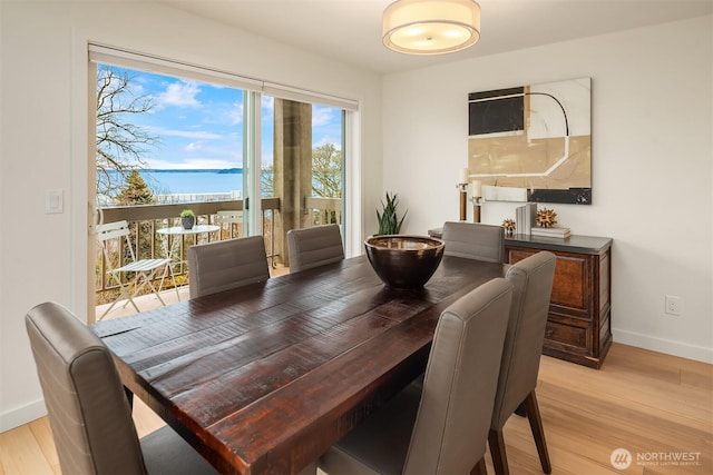 dining area featuring baseboards and light wood finished floors