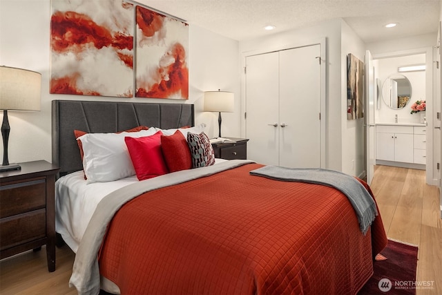 bedroom featuring recessed lighting, wood finished floors, a closet, and a textured ceiling