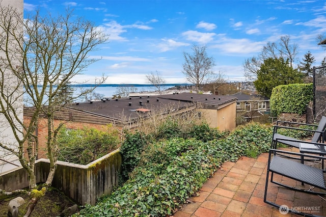 view of patio / terrace with fence and a water view