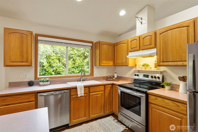 kitchen with under cabinet range hood, a sink, recessed lighting, stainless steel appliances, and light countertops