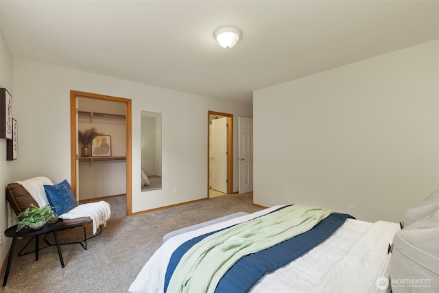 carpeted bedroom featuring a spacious closet, a closet, and baseboards