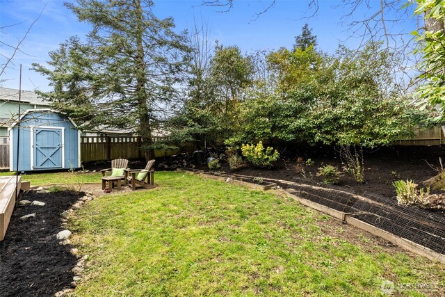 view of yard featuring fence, an outbuilding, and a shed