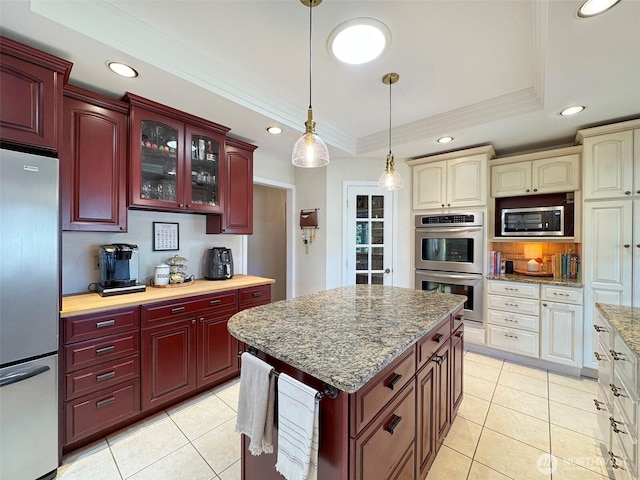 kitchen featuring reddish brown cabinets, ornamental molding, stainless steel appliances, and a raised ceiling