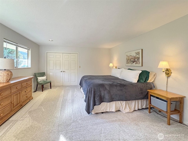 bedroom with light carpet, a closet, and a textured ceiling