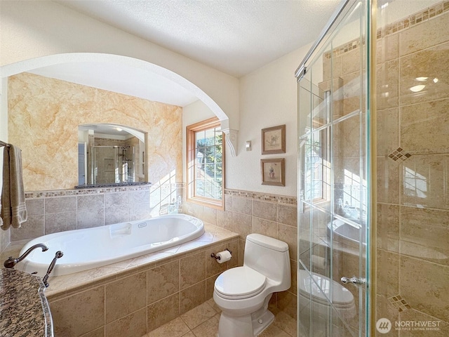 bathroom with tile walls, tile patterned floors, toilet, a stall shower, and a bath