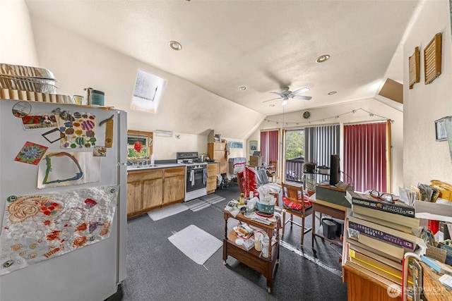 living area featuring dark colored carpet, lofted ceiling with skylight, and ceiling fan