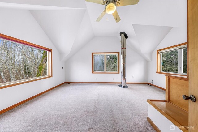 bonus room featuring lofted ceiling, carpet, baseboards, and ceiling fan