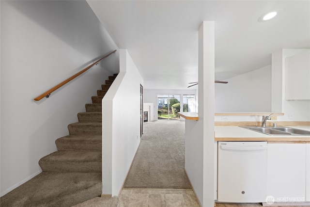 kitchen featuring a sink, light carpet, white cabinetry, and dishwasher