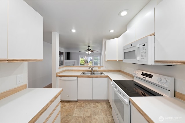 kitchen featuring light countertops, white appliances, a sink, and white cabinets