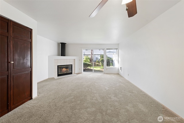 unfurnished living room featuring light carpet, ceiling fan, and a fireplace