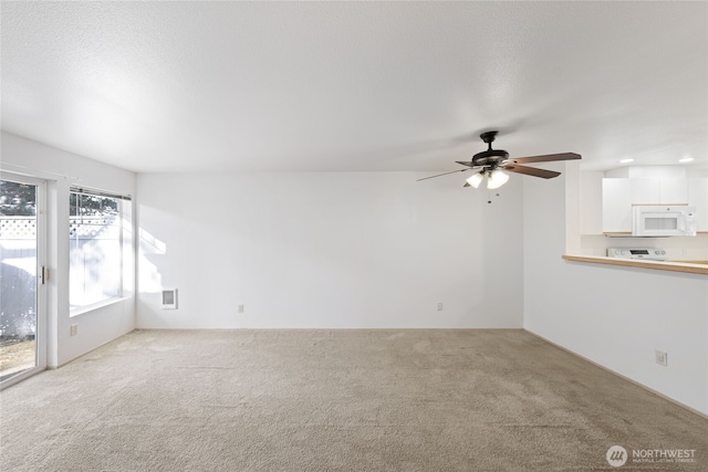 unfurnished living room featuring carpet and ceiling fan