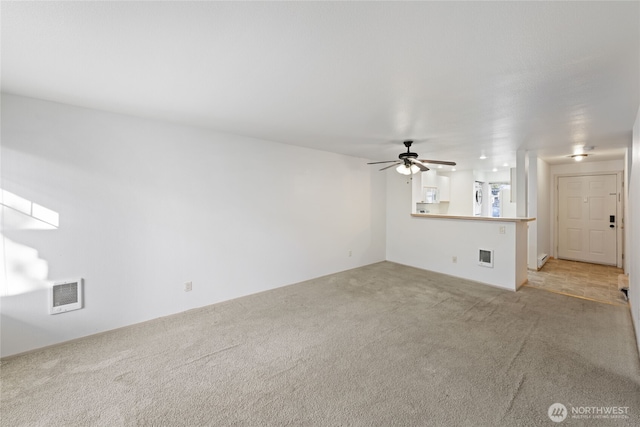 unfurnished living room featuring light carpet, visible vents, and a ceiling fan