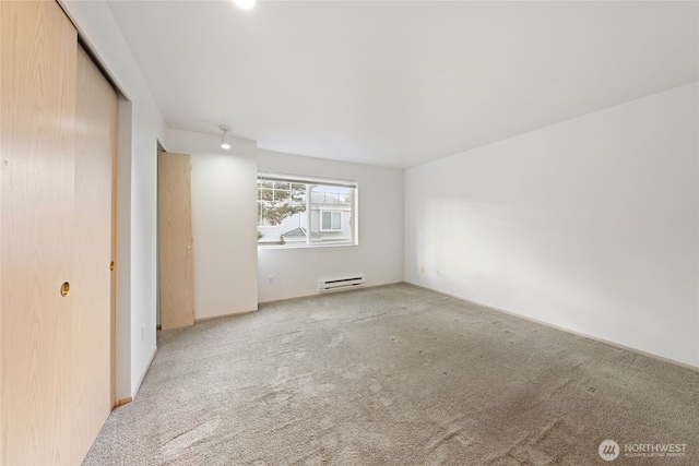 empty room with carpet floors and a baseboard radiator