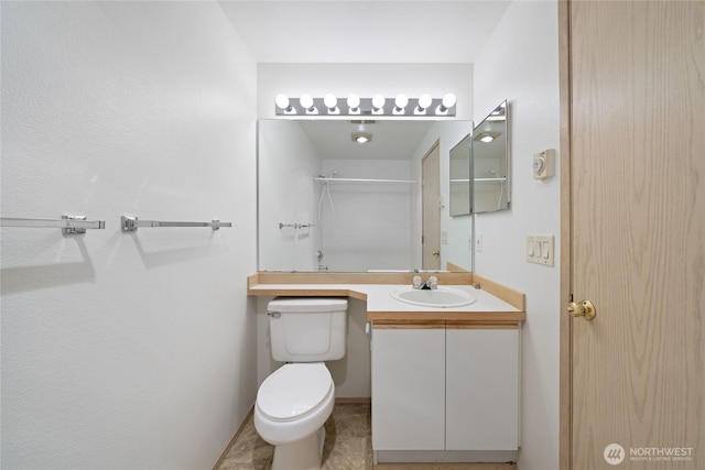 bathroom featuring toilet, walk in shower, and vanity