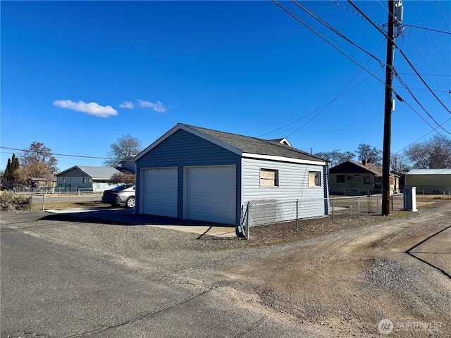 detached garage featuring fence