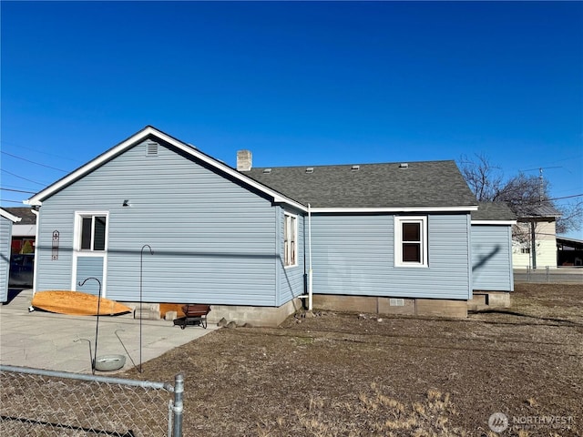 back of property with a patio, crawl space, roof with shingles, and fence