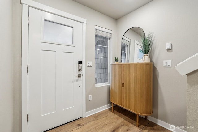 foyer with baseboards and wood finished floors