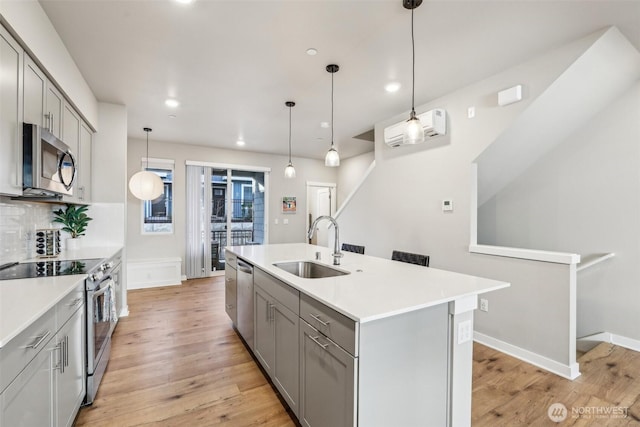 kitchen with a sink, stainless steel appliances, gray cabinets, and light countertops